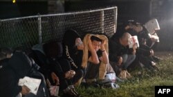 Migrants wait for a bus to take them to a processing center after they turned themselves over to US Border Patrol agents after crossing over from Mexico in Fronton, Texas, May 12, 2023.