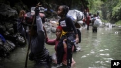 FILE - Haitian migrants wade through water as they cross the Darien Gap from Colombia to Panama in hopes of reaching the U.S., May 9, 2023. 