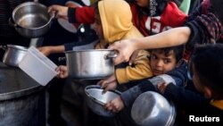 Anak-anak Palestina antre untuk menerima bantuan makanan yang dimasak oleh dapur amal di tengah kekurangan pasokan makanan di Rafah, di Jalur Gaza selatan (foto: dok). 