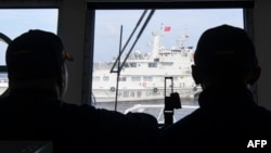 សមាជិកឆ្មាំឆ្នេរសមុទ្រហ្វីលីពីនមើលកប៉ាល់​ឆ្មាំ​ឆ្នេរ​សមុទ្រ​ចិន​ដែល​រាំង​ផ្លូវ​របស់​ពួកគេ អំឡុងពេល​បេសកកម្មផ្គត់ផ្គង់ឡើងវិញ​ដោយ​ទូកស៊ីវិល​ដែល​កងទ័ព​ជើងទឹក​ហ្វីលីពីន​បាន​ជួលដើម្បី​បញ្ជូន​ការផ្គត់ផ្គង់ដល់​នាវាកងទ័ពជើងទឹក​ហ្វីលីពីន នៅ​សមុទ្រ​ចិនខាងត្បូង នៅ​ថ្ងៃទី២២ ខែសីហា ឆ្នាំ២០២៣។