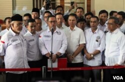 Ketua Tim Kuasa Hukum Paslon Nomor 1, Ari Yusuf Amir (tengah) memberikan keterangan kepada wartawan usai pendaftaran perkara Pemilu Presiden 2024 pada Rabu (20/3) di Gedung MK, Jakarta. (VOA/IndraYoga)