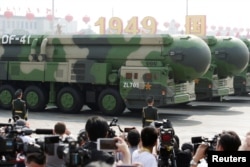 FILE - Military vehicles carrying DF-41 intercontinental ballistic missiles travel past Tiananmen Square during the military parade, Beijing, China, Oct. 1, 2019.