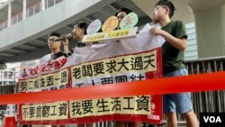 香港社民连4名成员，23条立法后首个五一劳动节到政府总部外请愿，在警方以红色胶带围封的示威区内拉横额及发言 (美国之音)