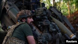A Ukrainian serviceman prepares to fire a howitzer toward Russian troops near the front line in Donetsk region, Ukraine May 1, 2024. 