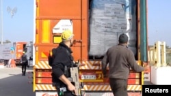 A humanitarian aid truck is inspected at the Kerem Shalom crossing, on the border between Israel, Gaza and Egypt, in this still image taken from video released Dec. 12, 2023. (COGAT via X via Reuters)