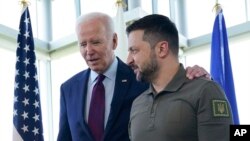 Presiden Ukraina Volodymyr Zelenskyy berjalan bersama Presiden AS Joe Biden sebelum sesi membahas situasi di Ukraina, dalam pertemuan puncak G7 di Hiroshima, Jepang, 21 Mei 2023. (Foto: Susan Walsh/AP Photo)