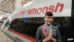 Seorang staf berpose usai peresmian kereta cepat Jakarta-Bandung 'Whoosh' di stasiun Halim Jakarta, 2 Oktober 2023. (Yasuyoshi CHIBA / AFP)