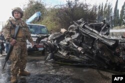 A Lebanese army soldier secures the site of an Israeli strike in Lebanon's southern area of Tyre, March 13, 2024.