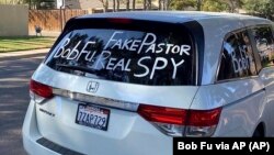 Sebuah mobil van yang terparkir di luar rumah Bob Fu di Midland, Texas, saat musim gugur 2020 dicoreti dengan tetulisan yang menuduh pendeta Kristen, warga AS keturunan Tionghoa itu, sebagai mata-mata Partai Komunis China.