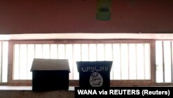 Bendera ISIS yang dilukis di atas rak buku terlihat di sel penjara Pul-e-Charkhi di Kabul, Afghanistan, 15 September 2021. (Foto: WANA via REUTERS)