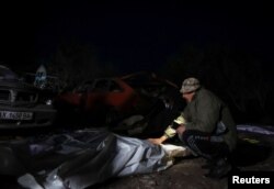 A man reacts near the body of a relative killed at the site of a Russian military strike in the village of Hroza in the Kharkiv region of Ukraine, Oct. 5, 2023.