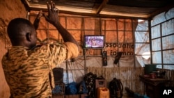 FILE - A soldier applauds the presidential inauguration of junta leader Lt. Col. Paul Henri Sandaogo Damiba during his swearing-in ceremony broadcast on national television, in Ouagadougou, Burkina Faso, Feb. 16, 2022. 