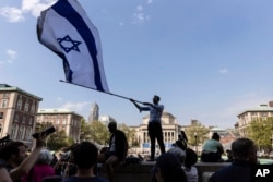 Columbia University sophomore David Lederer waves a large flag of Israel outside the student protest encampment on the campus, April 29, 2024, in New York.