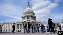 FILE - Visitors walk outside of the U.S. Capitol, March 19, 2024, in Washington. 