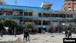 Warga Palestina memeriksa lokasi serangan Israel terhadap sekolah UNRWA yang menampung para pengungsi, di tengah konflik Israel-Hamas, di kamp pengungsi Nuseirat di Jalur Gaza tengah, 6 Juni 2024.
