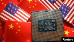 FILE: Sebuah chip semikonduktor unit pemrosesan pusat (CPU) ditampilkan di antara bendera China dan Amerika Serikat, 17 Februari 2023. (Florence Lo/REUTERS)