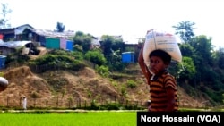 FILE - Seorang anak laki-laki Rohingya membawa jatah makanan untuk keluarganya dari toko yang dikelola Program Pangan Dunia PBB (WFP) di kamp pengungsi Cox's Bazar, Bangladesh.