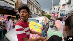FILE - A vendor sells clothes for small children in Kolkata, India, Wednesday, June 21, 2023. Prior to Jan. 1, 2001, the city was known as Calcutta.
