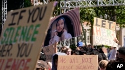 Students hold up a photo of University of Southern California 2024 valedictorian Asna Tabassum in protest to her canceled commencement speech on the campus of University of Southern California, in Los Angeles, April 18, 2024. 