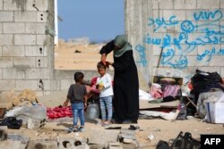 Seorang pengungsi Palestina menyisir rambut putrinya di kamp sementara di Rafah pada 17 Mei 2024. (Foto: AFP)