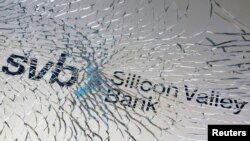 路透社资料照 - 一块被打碎的玻璃下隐约可见硅谷银行的英文招牌。