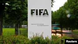 Mobil melewati logo di depan markas FIFA di Zurich, Swiss, 8 Juni 2016. (Foto: REUTERS/Arnd Wiegmann)