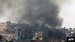 2023年12月27日，在以色列南部与加沙地带接壤的地方拍摄的一张照片显示，以色列轰炸巴勒斯坦领土后冒出的浓烟。（法新社照片）