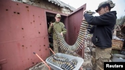 乌克兰军人在巴赫穆特前线阵地给防空高炮装载弹药。（2023年4月12日）