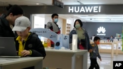 资料照：顾客正在北京一家商场的华为商店参加华为产品。（2023年4月28日）