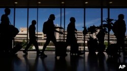 Travelers walk through the Philadelphia International Airport, July 3, 2024. 