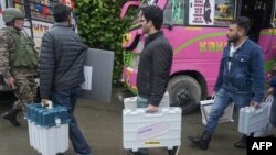 Kashmiri polling officials carry Electronic Voting Machines (EVM) ahead of the fourth phase of voting of India's general elections in Srinagar, May 12, 2024. 