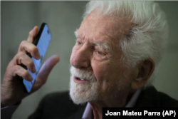 Marti Kuper sa novim modelom mobilnog telefona (Foto: AP/Joan Mateu Parra)