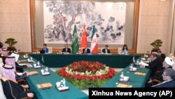 Dalam foto yang dirilis oleh Kantor Berita Xinhua ini, Wang Yi, diplomat paling senior China (tengah), memimpin pertemuan tertutup antara para pemimpin dari Iran dan Arab Saudi di Beijing, 11 Maret 2023.