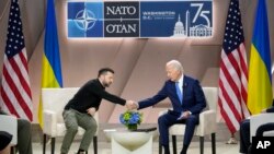 President Joe Biden, right, shakes the hand of Ukraine's President Volodymyr Zelenskyy during a meeting on the sidelines of the NATO Summit in Washington, July 11, 2024. 