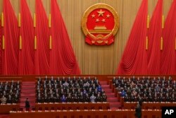 Delegates applaud as Chinese President Xi Jinping, left, arrives at the closing ceremony for China's National People's Congress (NPC) at the Great Hall of the People in Beijing, March 13, 2023.