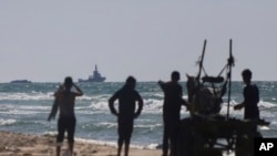 A ship belonging to the Open Arms aid group approaches the shores of Gaza towing a barge with 200 tons of humanitarian aid, March 15, 2024. The ship set sail Tuesday from Cyprus to inaugurate a sea route to get aid into the war-wracked enclave.