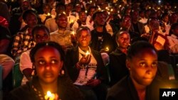 Young Rwandans hold flameless candles while taking part on a vigil during the commemorations of the 30th Anniversary of the 1994 Rwandan genocide at the BK Arena in Kigali, April 7, 2024. 