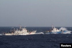 រូបឯកសារ៖ នាវារបស់កងឆ្មាំជើងទឹកវៀតណាមធ្វើដំណើរនៅក្បែរនាវារបស់កងឆ្មាំសមុទ្ររបស់ចិន នៅតំបន់សមុទ្រចិនខាងត្បូង ស្ថិតក្នុងចម្ងាយ ២១០គីឡូម៉ែត្រ ពីឆ្នេរវៀតណាម កាលពីថ្ងៃទី ១៤ ខែឧសភា ឆ្នាំ ២០១៤។