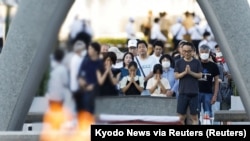 Orang-orang berdoa di depan monumen makam untuk para korban bom atom pertama di Taman Monumen Perdamaian dalam peringatan 78 Tahun pengeboman Hiroshima, di Hiroshima, Jepang, Minggu, 6 Agustus 2023. (Foto: Kyodo News via Reuters)
