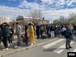 Glasači čekaju ispred biračkog mesta na kom se glasa za predsednika Rusije, na Novom Beogradu, nešto iza podneva, 17. marta 2024. Opozicioni lideri pozvali su protivnike Vladimira Putina da se u podne okupe ispred birališta i tako iskažu svoj protest. (Foto: VoA/Stefan Miljuš)