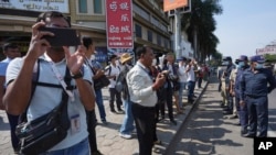 រូបឯកសារ៖ អ្នក​សារព័ត៌មាន​ផ្តិត​យក​ព័ត៌មាន​ជុំវិញ​ដំណើរការ​កាត់​ទោស​លោក កឹម សុខា នៅ​មុខ​សាលាដំបូង​រាជធានី​ភ្នំពេញ កាលពីថ្ងៃទី៣ ខែមីនា ឆ្នាំ២០២៣។ 