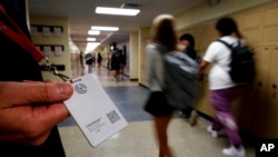 Salah satu petugas sekolah di SMA Olathe South di Olathe, Kansas, menunjukkan tombol peringatan bahaya yang diberlakukan dii sekolah tersebut pada 19 Agustus 2022. (Foto: AP/Charlie Riedel)