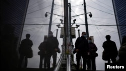 人们行走在装有监控摄像头的上海街头。（2022年12月12日）