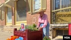 Margaret Harris tends to flowers left for Joan Meyer, her friend and co-owner of the Marion County Record who died one day after police raided her newspaper and her home. (VOA/Liam Scott)