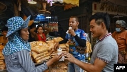 A vendor serves ice cream to flower vendors during a heatwave in Bangkok on April 25, 2023. 