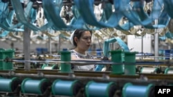 Seorang pekerja memproduksi produk sutra di sebuah pabrik tekstil di Fuyang, di Provinsi Anhui, China timur, pada 16 April 2024. (Foto: AFP)