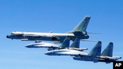 Dua jet tempur Su-35 dan pesawat pembom H-6K milik tentara China terbang dalam patroli ke sejumlah wilayah yang mencakup Selat Luzon atau yang dikenal juga dengan sebutan Selat Bashi di dekat Taiwan pada 11 Mei 2018. (Foto: Han Chao/Xinhua via AP)