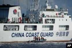 A Chinese coast guard ship deploys its crew on motor boats to monitor activities from two Philippine coast guard vessels near the Second Thomas Shoal at the South China Sea, April 23, 2023.