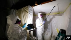 资料照片:工作人员在密歇根州的霍维尔进行石棉消除工作。(2017年10月18日)
