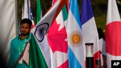 Radnik nosi državnu zastavu Indije kako bi je postavio uz zastave ostalih zemalja učesnica sednice ministara spoljnih poslova zemalja G-20, u Nju Delhiju, u Indiji, 2. marta 2023.